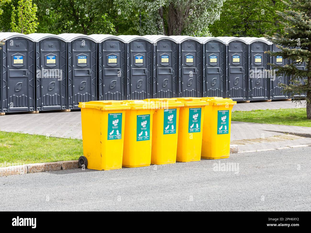 Samara, Russia - May 21, 2022: Portable public toilets and plastic trash containers at the city street in summer Stock Photo