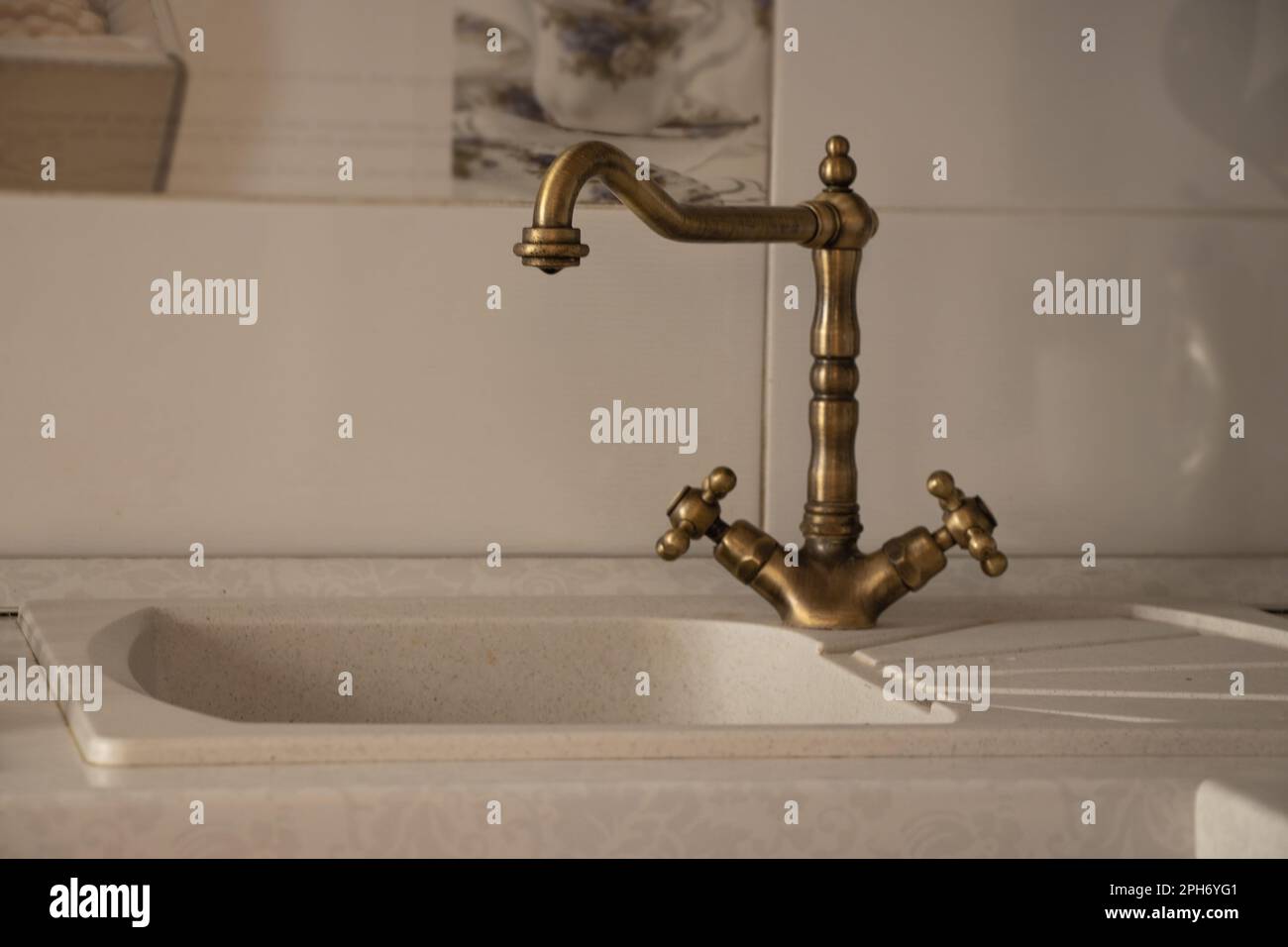 kitchen faucet on the kitchen in a retro style on the background of white tiles, kitchen sink Stock Photo