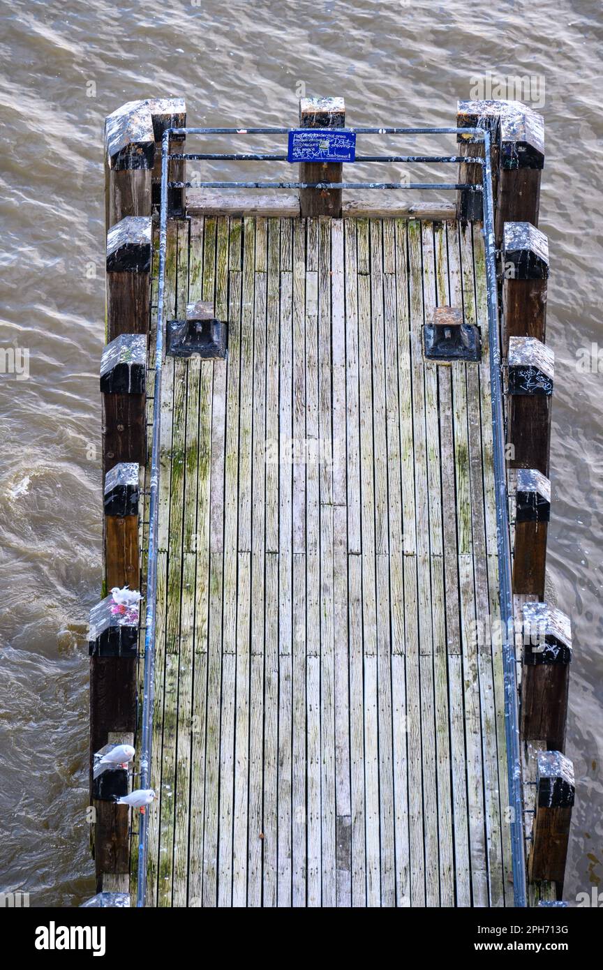 Enjoy a captivating aerial view of a jetty on the River Thames from above. Experience the charm