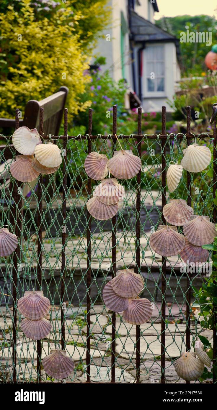 https://c8.alamy.com/comp/2PH7580/creative-use-of-beach-combing-findings-including-shells-and-old-fishing-net-to-decorate-garden-walls-and-gates-in-cornwall-2PH7580.jpg
