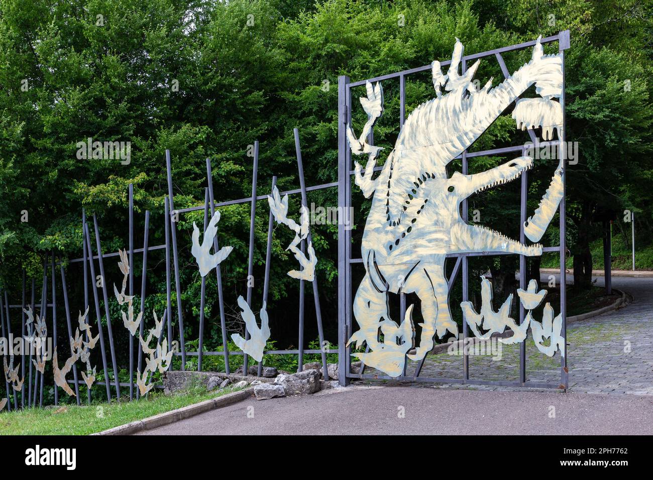 Entrance to Sataplia Strict Nature Reserve in Georgia, metal entry gate to the natural park with dinosaur shapes. Stock Photo