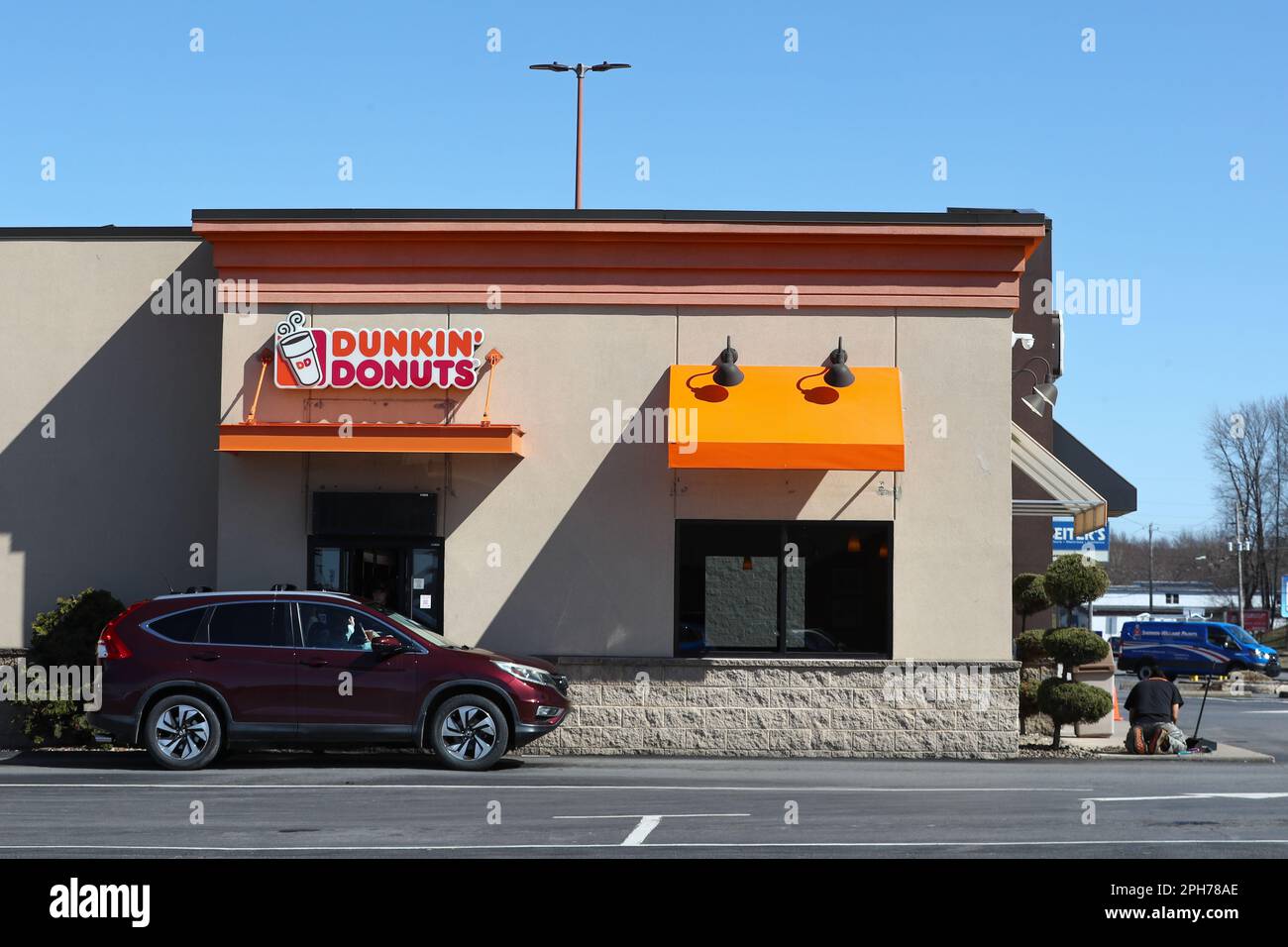 A customer picks up an order at the Dunkin' Donuts drivethru window