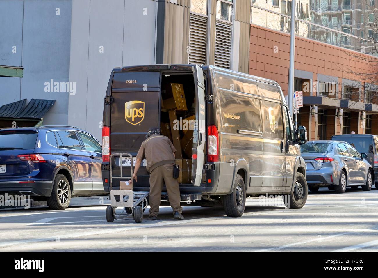 Austin, Texas, USA February 2023 Person unloading parcels from a UPS