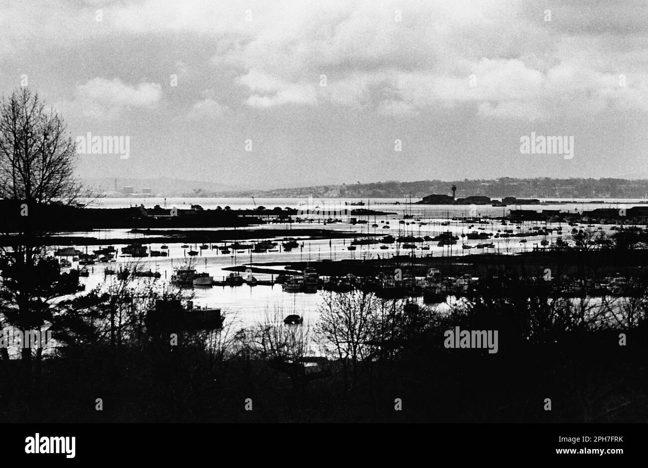 AJAXNETPHOTO. 1976. BURSLEDON, ENGLAND. - YACHTING MECCA -  FAMOUS HAMBLE RIVER WINDING SOUTH WEST TOWARD SOUTHAMPTON WATER AND THE SOLENT; RIVER HAS MOORINGS FOR MORE THAN 3500 BOATS ON TROTS AND AT SEVERAL LARGE MARINAS. RIVER EMPTIES INTO LOWER REACHES OF SOUTHAMPTON WATER FROM WHERE YACHTS CAN NAVIGATE THE 5 MILE SOLENT CROSSING TO COWES (BACKGROUND). FAMED CALSHOT RADAR TOWER, OUTPOST FOR SOUTHAMPTON PORT CONTROL IS SEEN SILHOUETTED RIGHT CENTRE.PHOTO:PETER EASTLAND/AJAX REF:MX340 220605 11 (762204 GR2) Stock Photo
