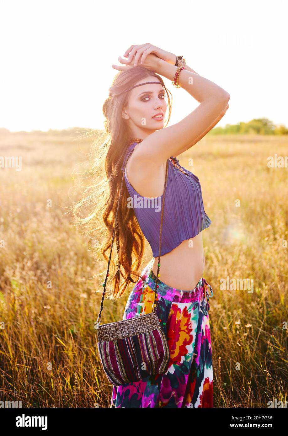 Outdoor portrait of the smiling beautiful young boho (hippie) girl in field Stock Photo