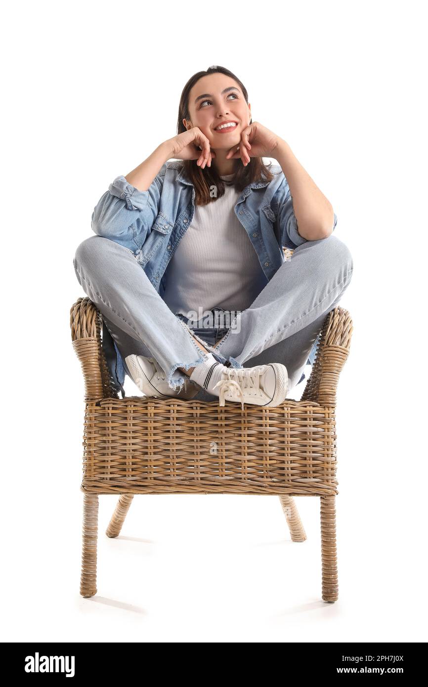 Young woman sitting in wicker armchair on white background Stock Photo ...