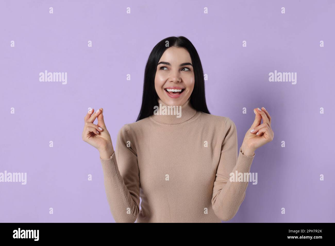 Young woman snapping fingers on violet background Stock Photo
