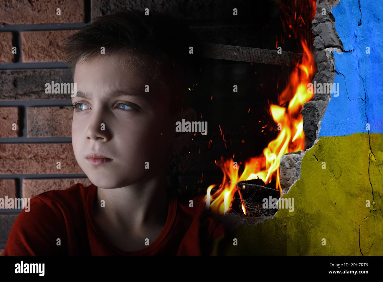 Sad little boy and wall of ruined building painted in color of national flag on fire. Stop war in Ukraine Stock Photo