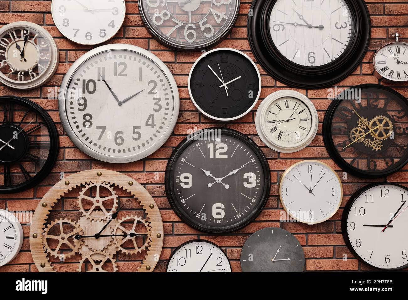 Collection of clocks hanging on red brick wall Stock Photo Alamy