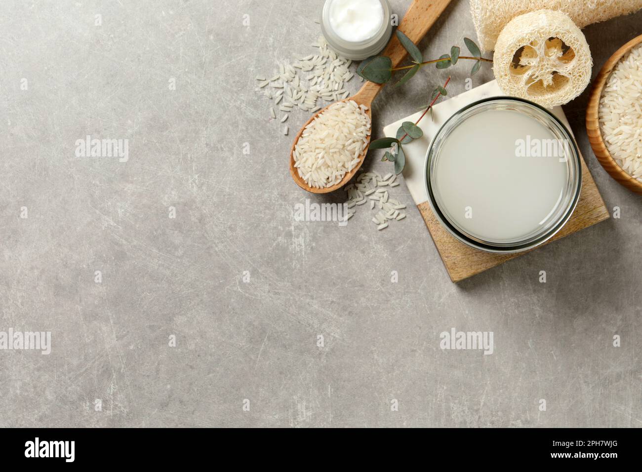 Flat lay composition with natural rice water on light grey table. Space ...
