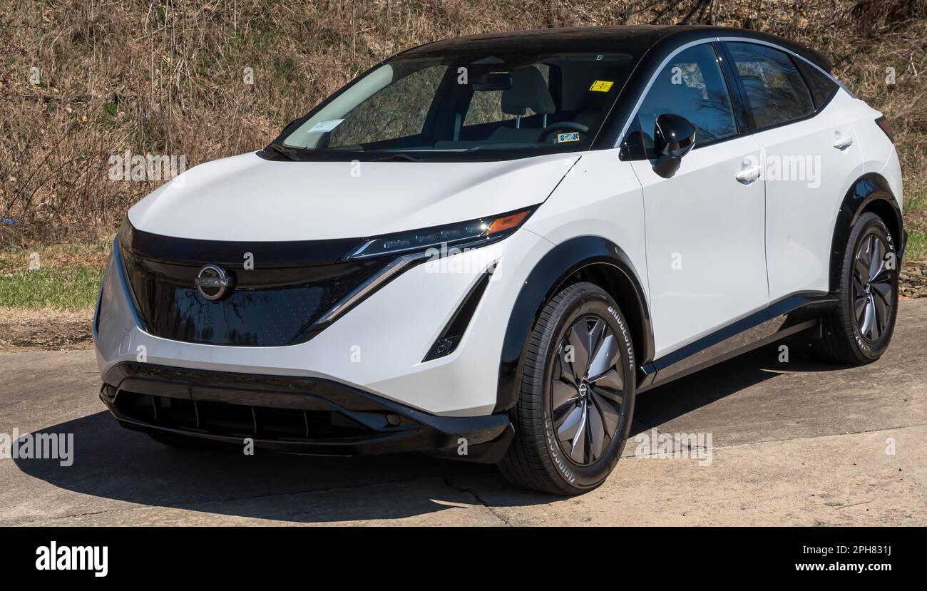 A new, white Nissan sedan hatchback for sale at a dealership in Wilkins