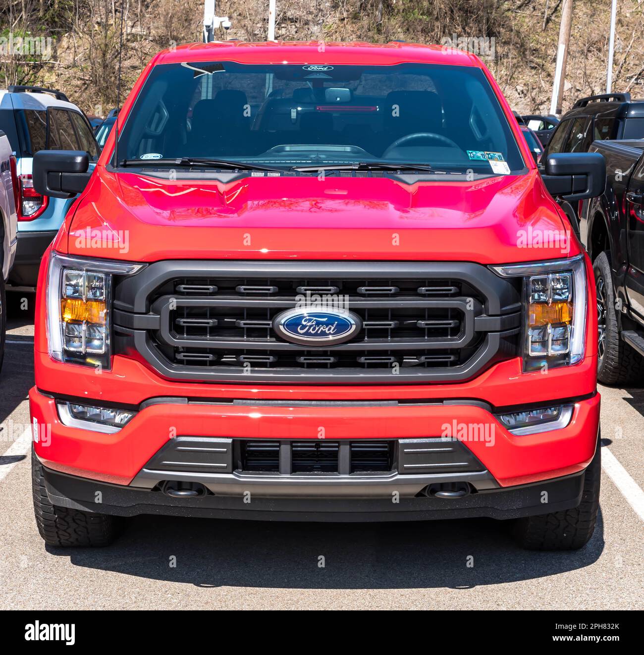 A red Ford F150 pickup truck for sale at a dealership in Monroeville