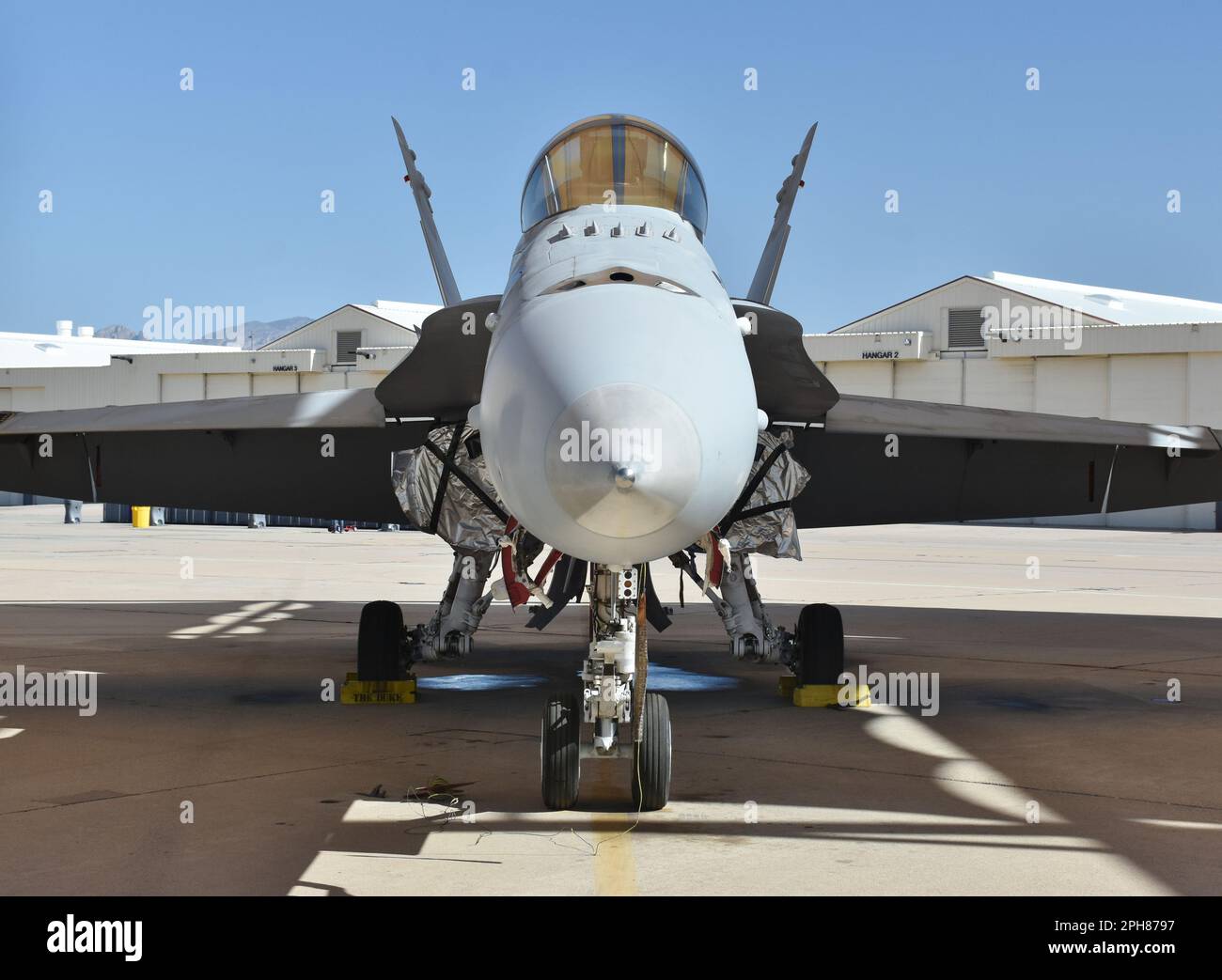 A U.S. Navy F/A-18 Super Hornet fighter jet parked in a hangar. Stock Photo