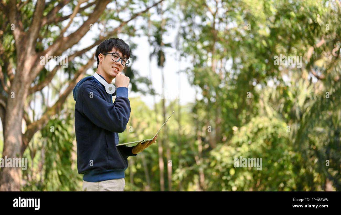 Portrait of a handsome smart young Asian male college student with his ...
