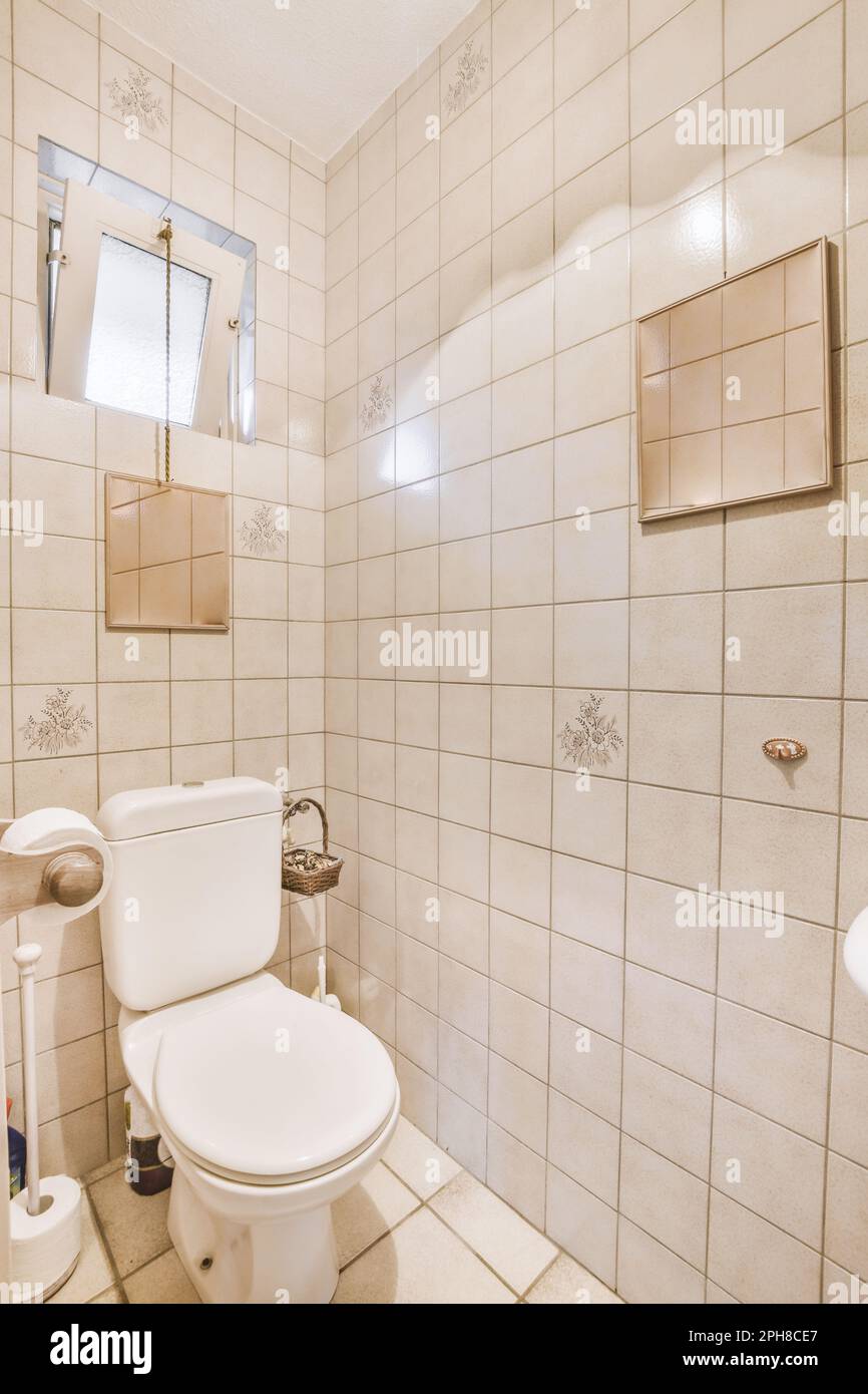 a white toilet in a bathroom with tile on the floor and wall behind it