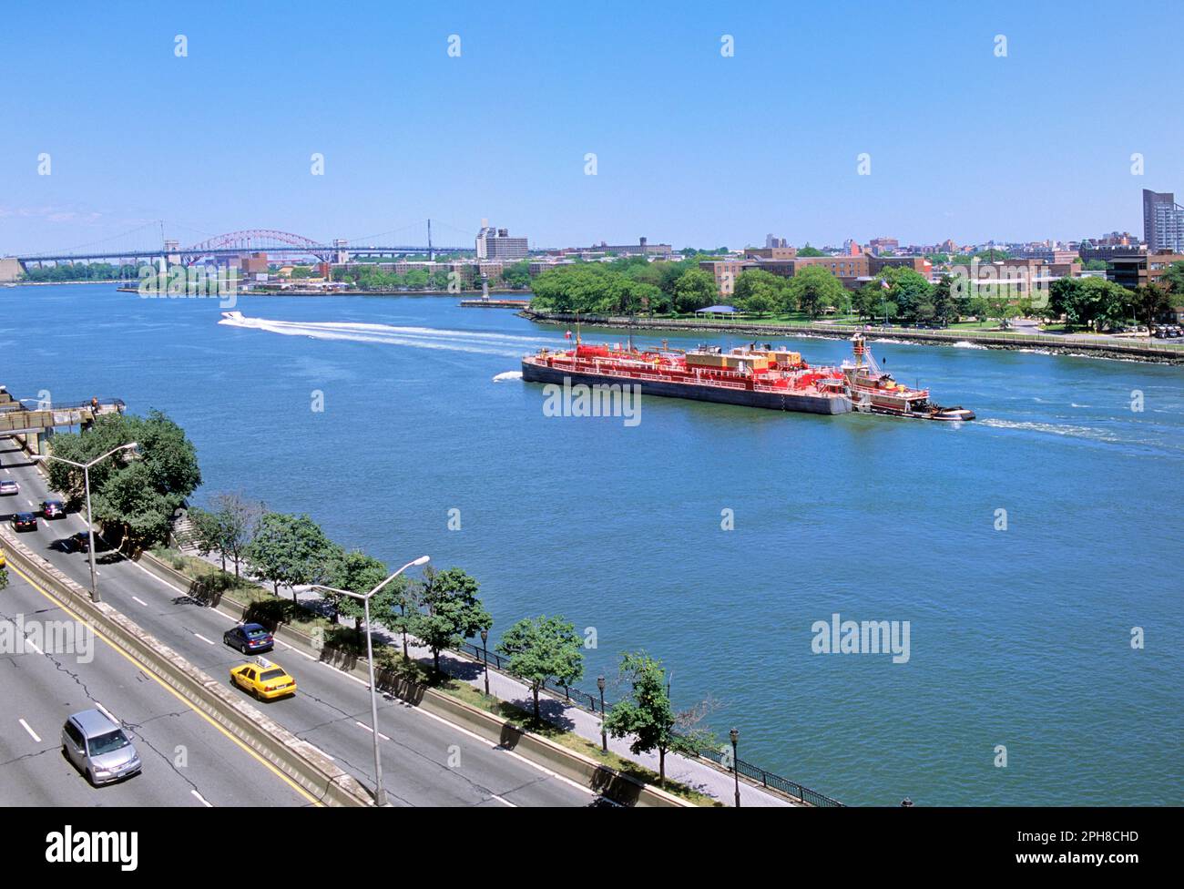 Tugboat and red barge on the East River. Upper East Side high angle view of commercial river traffic on the FDR Drive in New York City USA Stock Photo