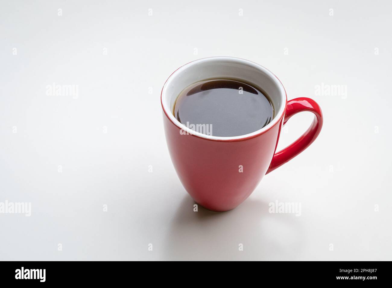 Coffee in red cup, isolated on white background. Copy space. Stock Photo