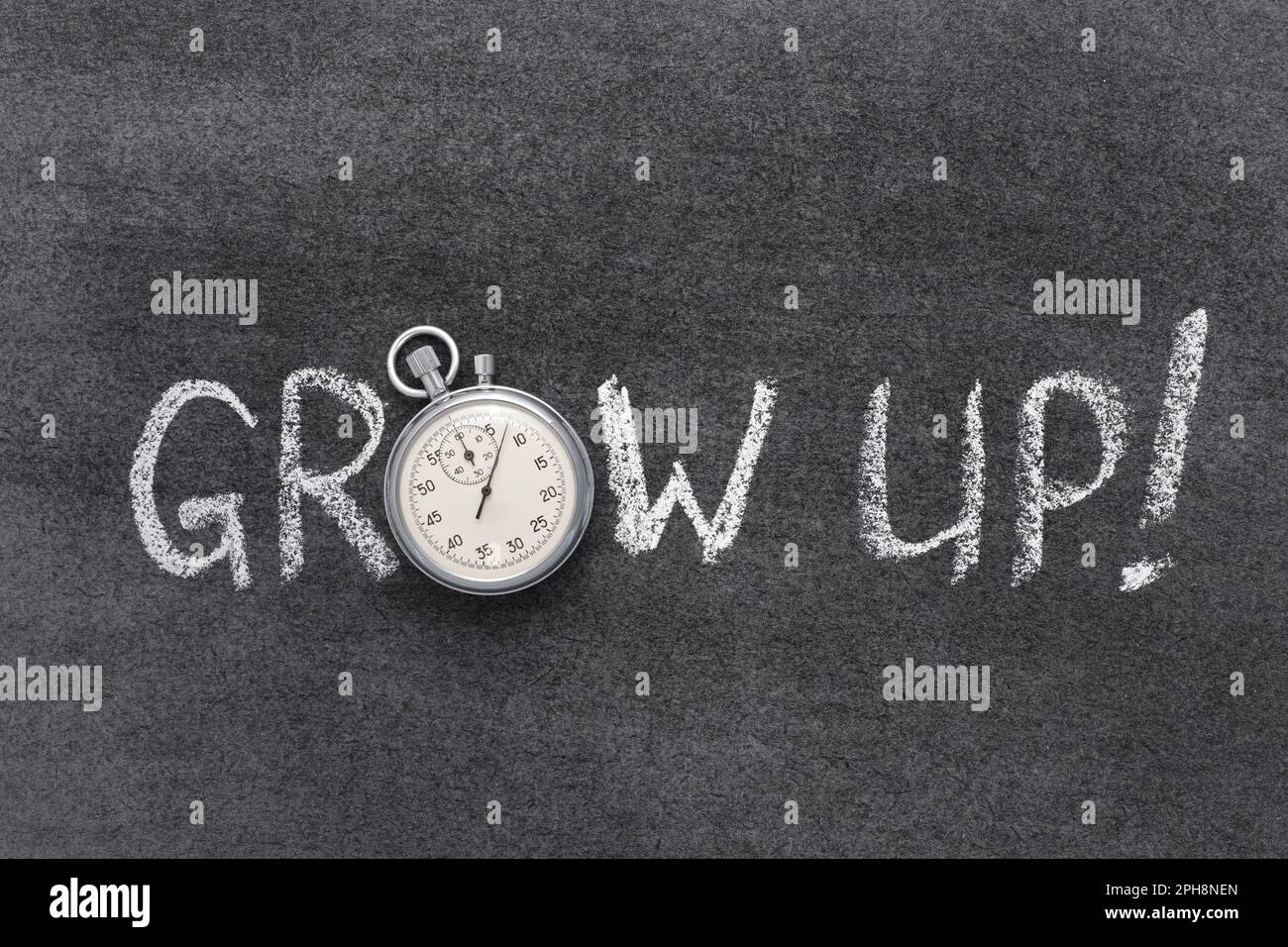 grow up slogan handwritten on chalkboard with vintage precise stopwatch used instead of O Stock Photo