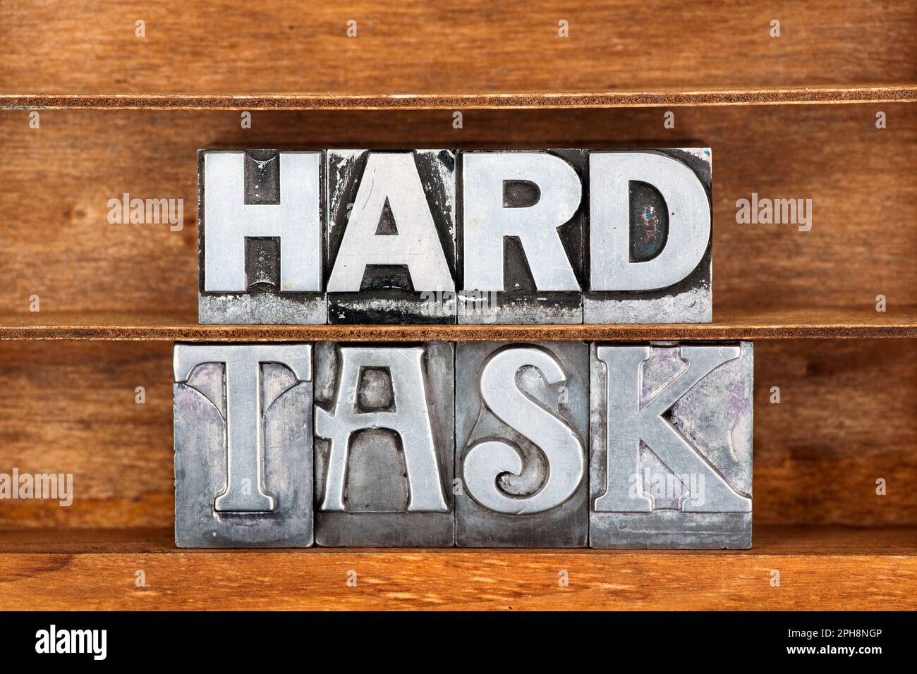 hard task phrase made from metallic letterpress type on wooden tray Stock Photo