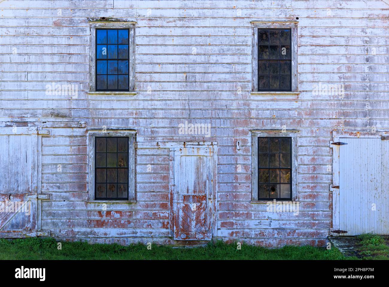 Faded white paint on wall, doors, and windows of historic western ...