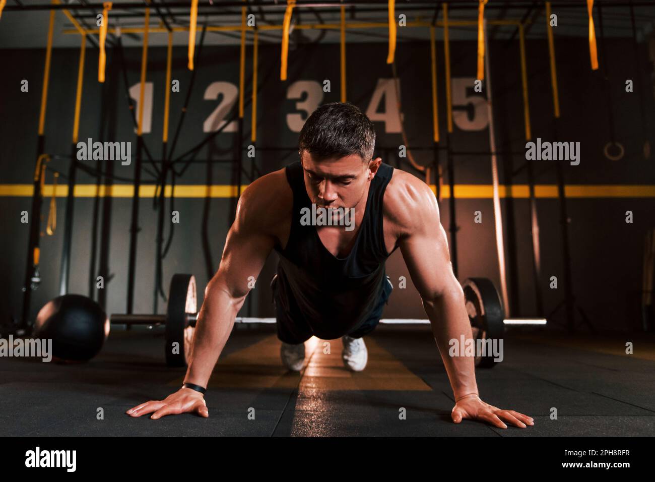 Strong man in sportive clothes doing push-ups in the gym Stock Photo ...