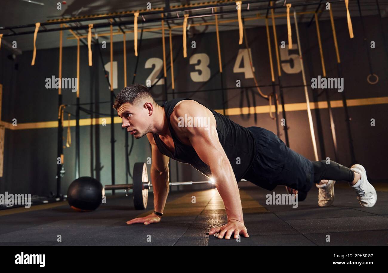 Strong man in sportive clothes doing push-ups in the gym Stock Photo ...