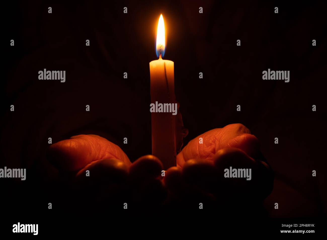 old woman's hands and candle flame in the dark, candle light, mourning ...