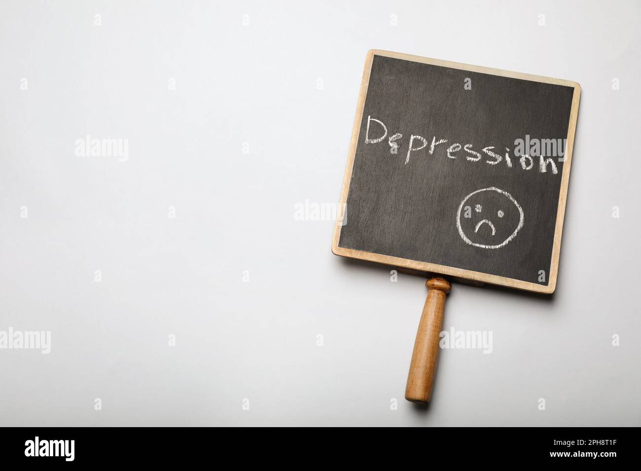 Chalkboard with word Depression and drawing of sad face on white background, top view. Space for text Stock Photo