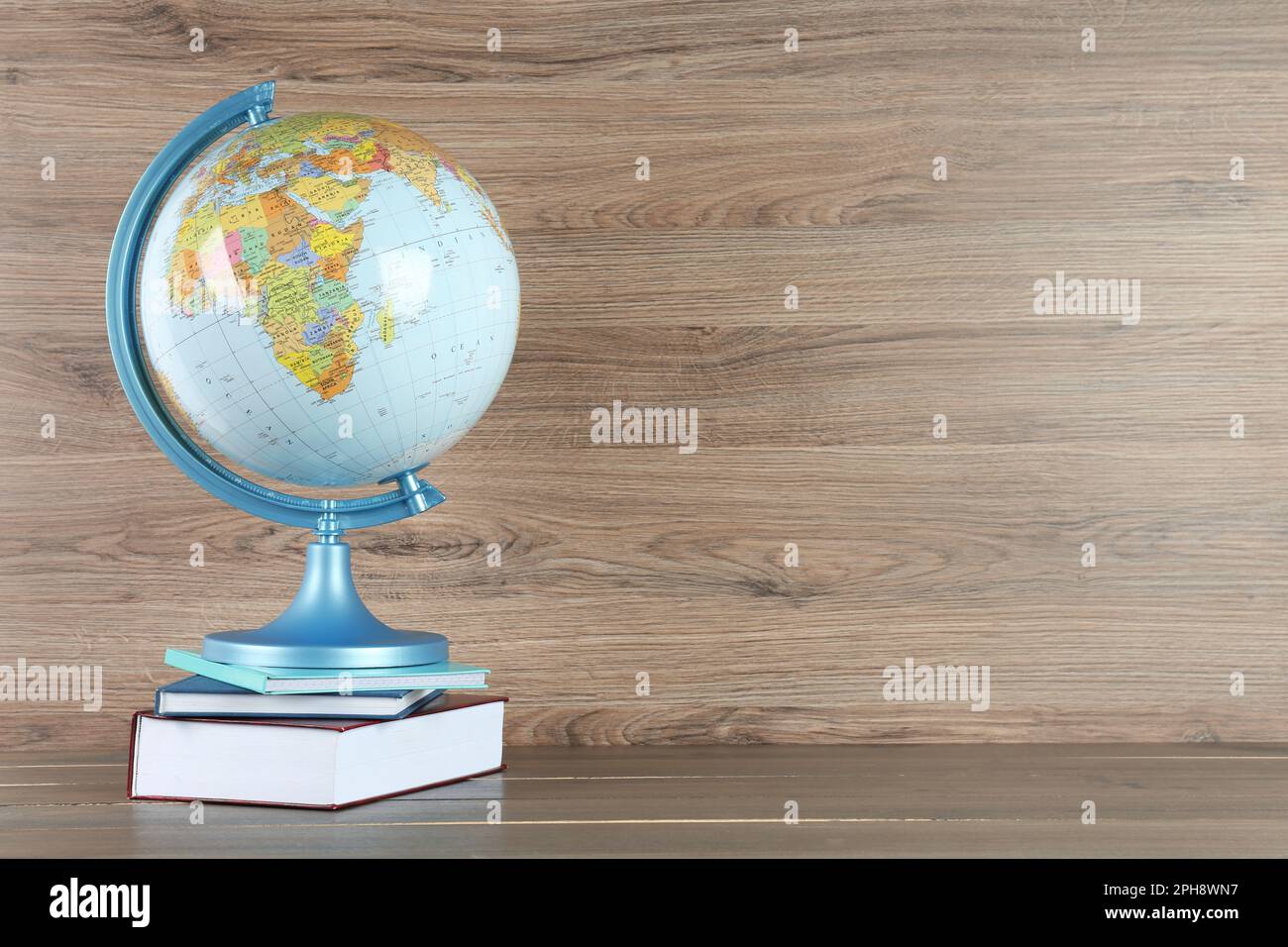 Globe and books on wooden table, space for text. Geography lesson Stock ...