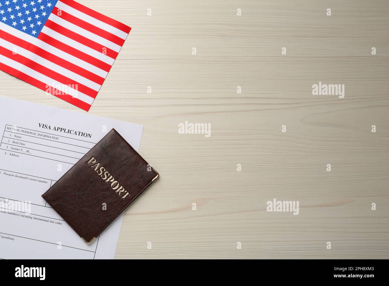 American flag, visa application form and passport on white wooden table, flat lay. Space for text Stock Photo