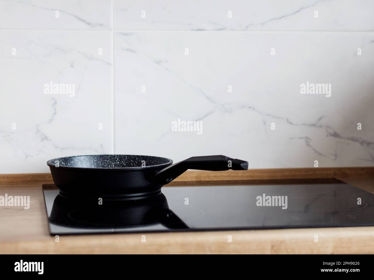Frying pan on modern black induction stove, cooker, hob or built in