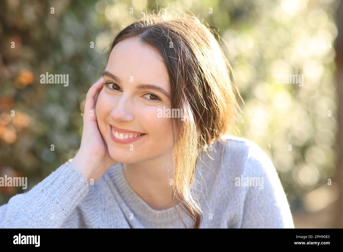 Portrait of a beautiful woman posing sitting in a park Stock Photo