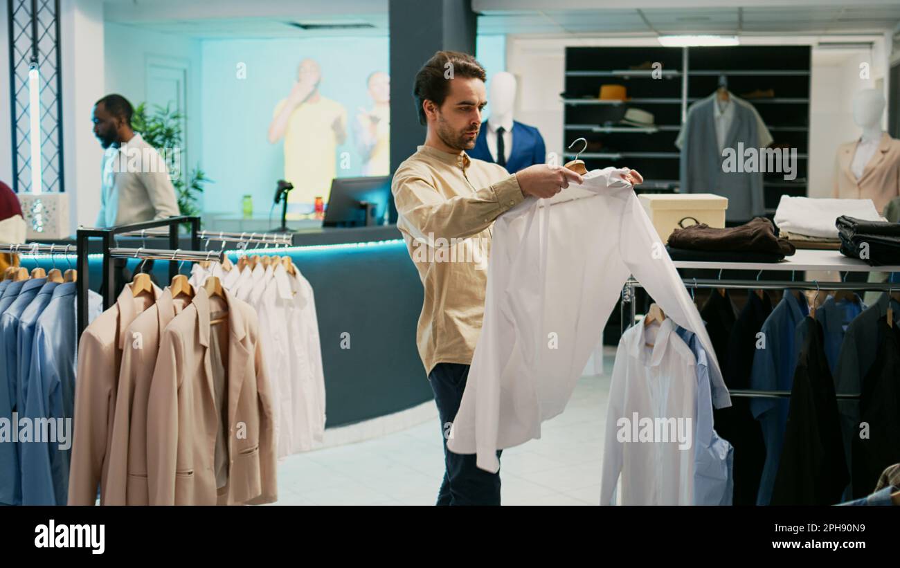 Young person buying casual wear in department store, caucasian man 