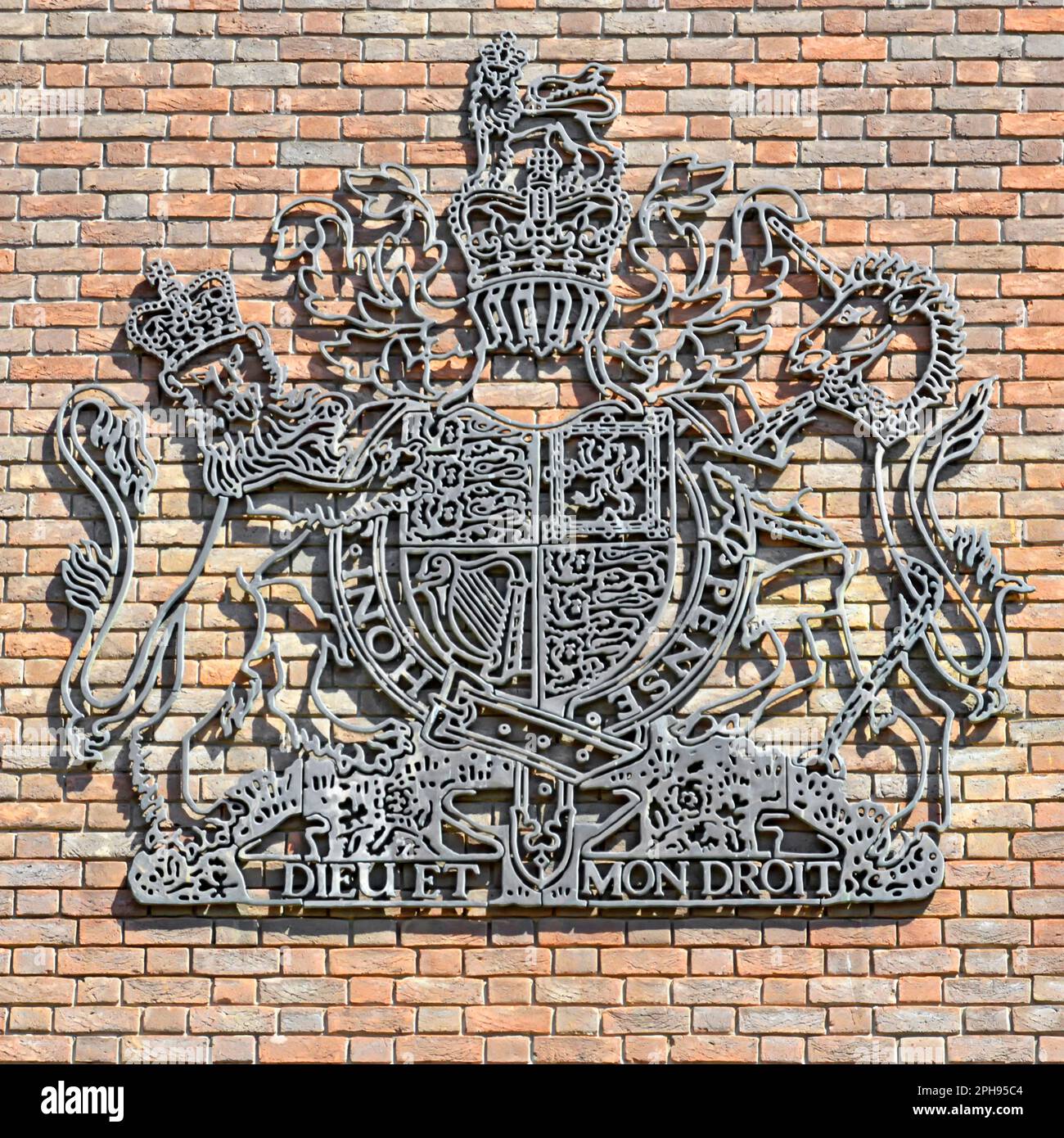 Chelmsford Crown Court close up of dark grey Royal Coat of arms of the United Kingdom on external brick wall of modern court building Essex England UK Stock Photo