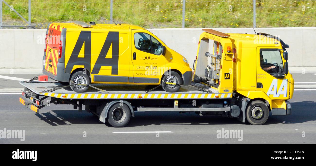 The Automobile Association trading name of AA breakdown rescue services lorry truck loaded with an AA van driving along M25 Motorway Essex England UK Stock Photo