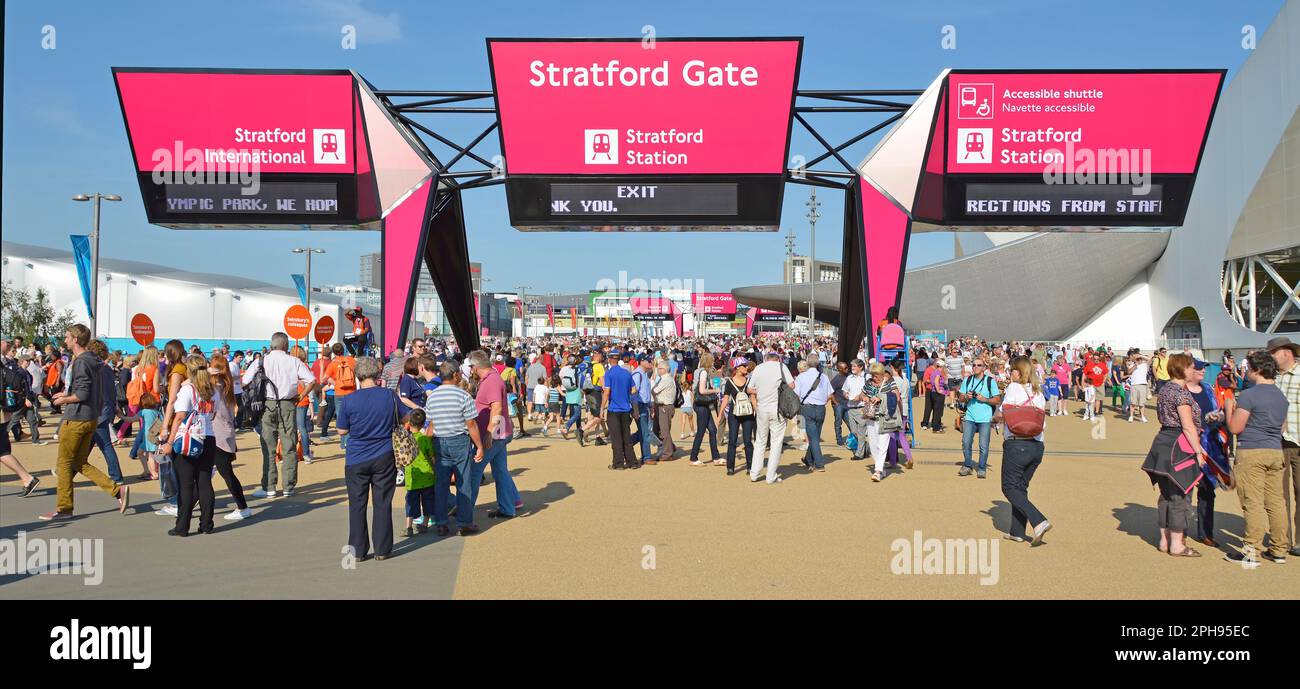 Spectators groups meeting up below Stratford exit gate sign before departing London 2012 Paralympic games on blue sky day in Olympic Park England UK Stock Photo