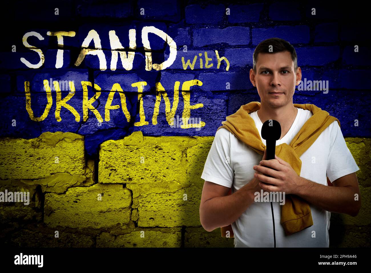 Journalist near wall painted in colors of Ukrainian flag with words