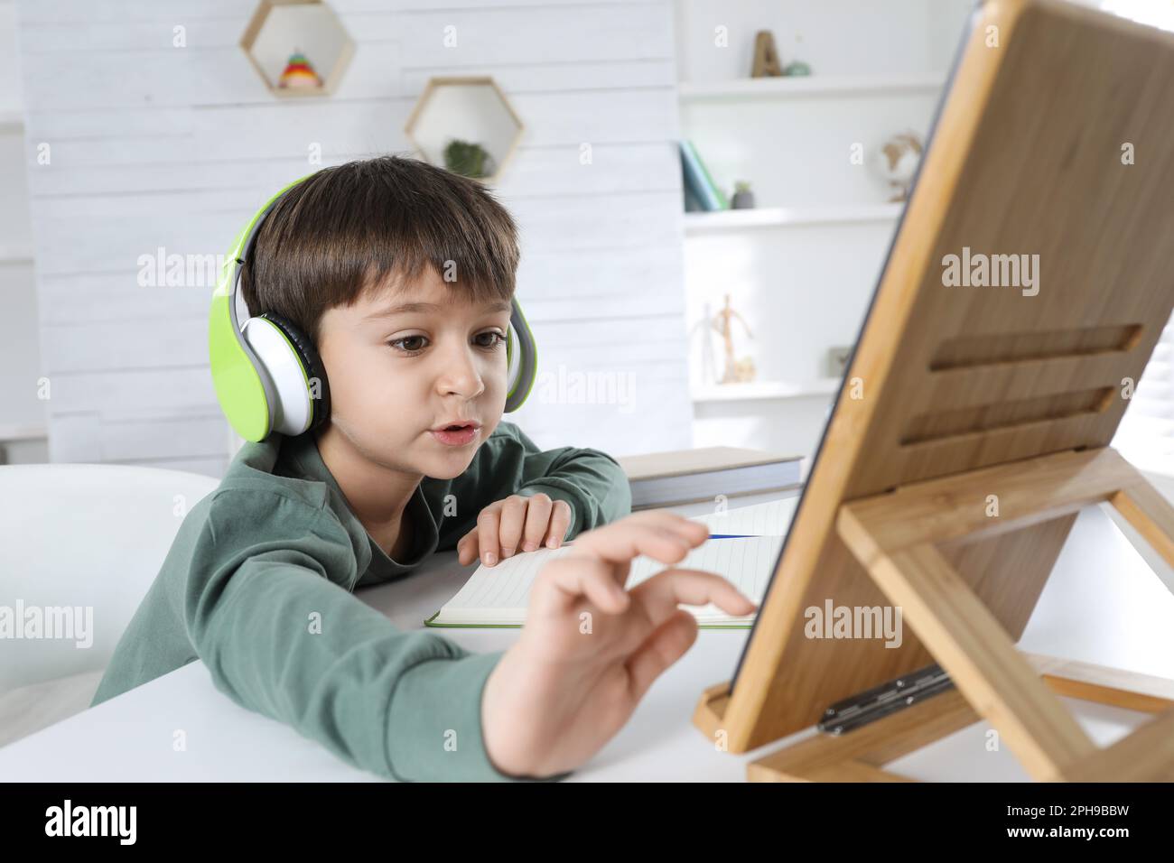Cute little boy with modern tablet studying online at home. E-learning ...