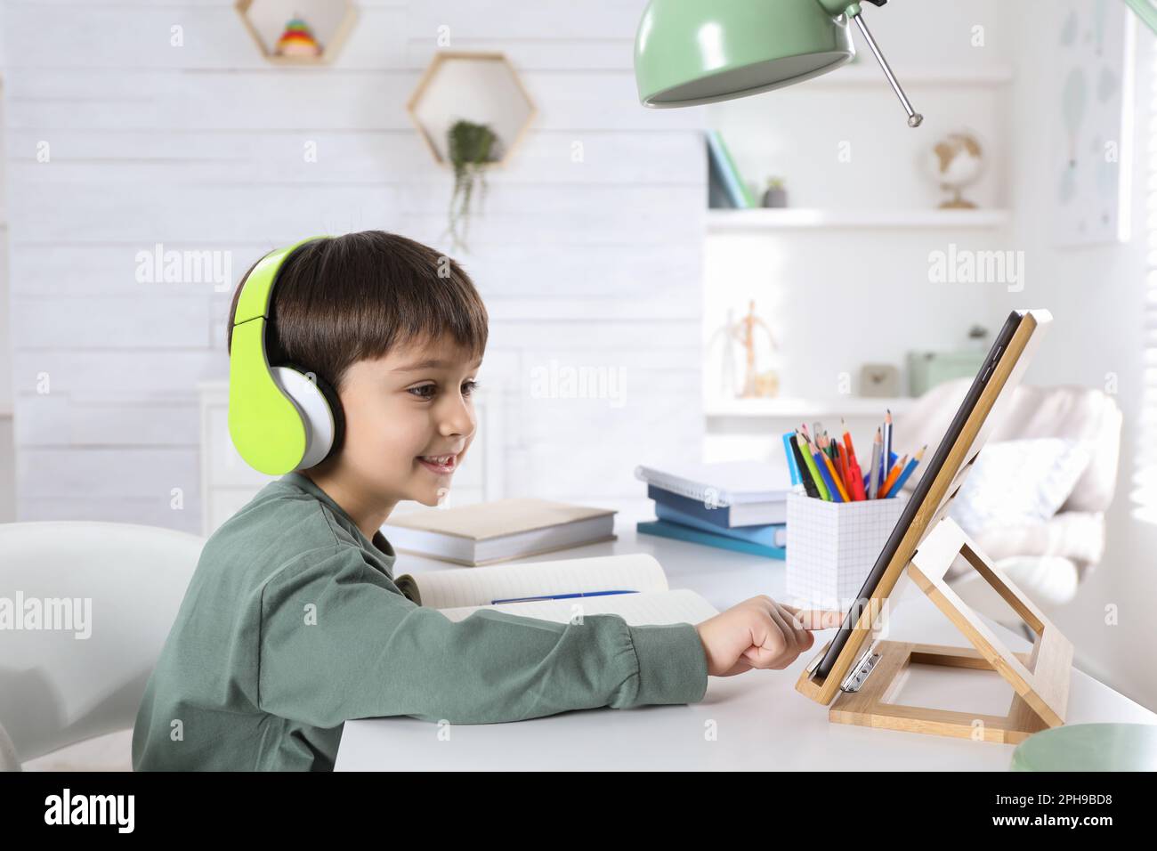 Cute little boy with modern tablet studying online at home. E-learning ...