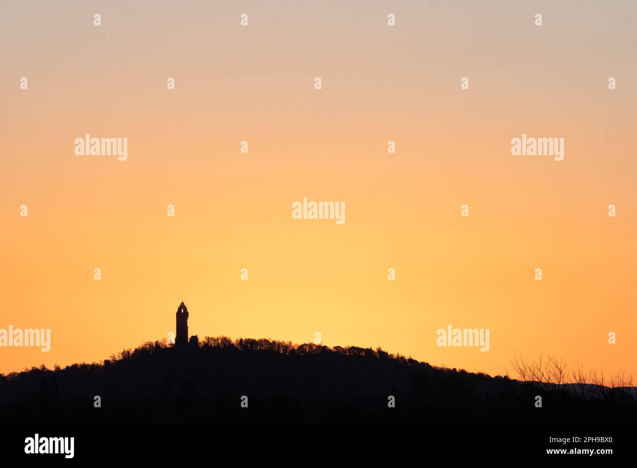 Stirling, Scotland, UK. 27th Mar, 2023. UK weather - a chilly sunrise in Stirling, Scotland. Pictured: the distinctive silhouette of the Wallace Monument Credit: Kay Roxby/Alamy Live News Stock Photo