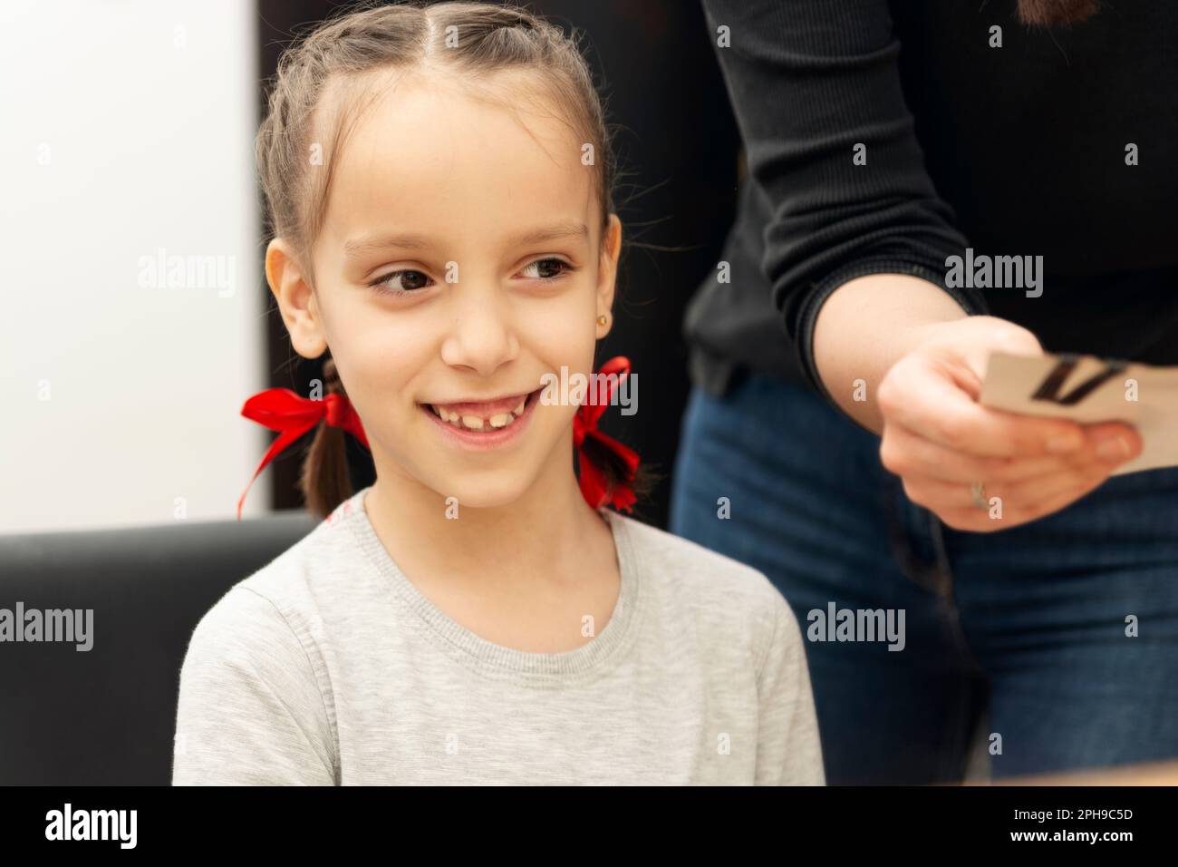Reflection in a mirror of a cute little girl at hair salon Stock Photo