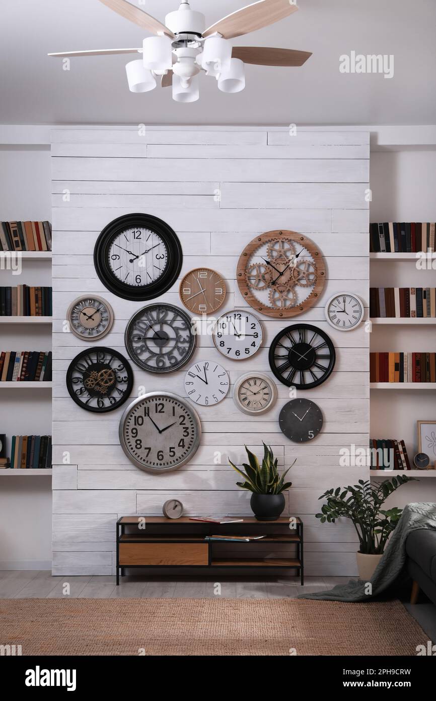 Stylish room interior with console table, beautiful houseplants and collection of different