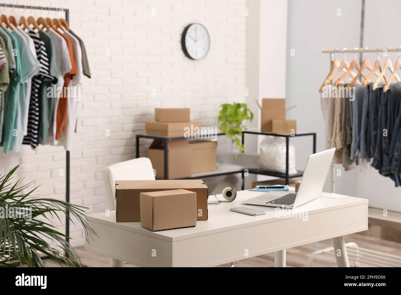 Store With Boxes Store interior with clothing racks, cardboard boxes and laptop. Online ...