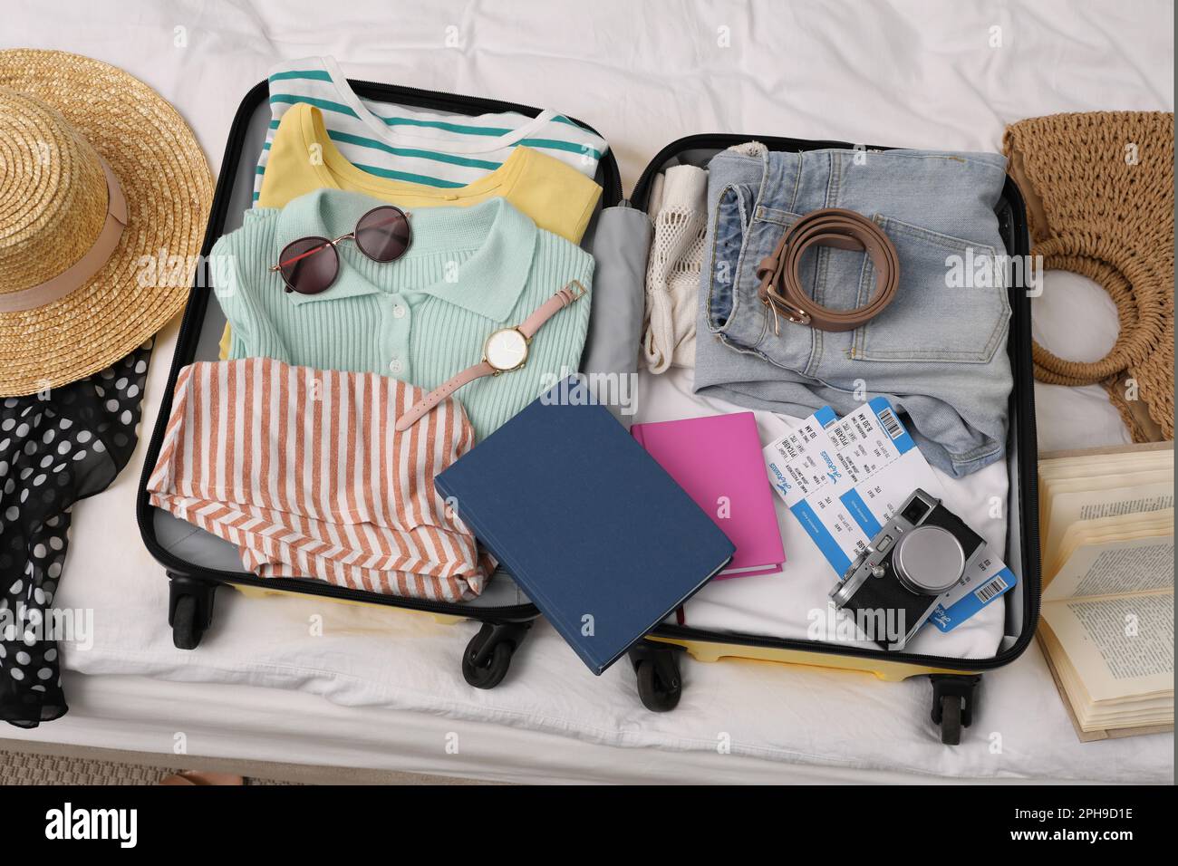 https://c8.alamy.com/comp/2PH9D1E/open-suitcase-with-clothes-and-accessories-on-bed-flat-lay-2PH9D1E.jpg