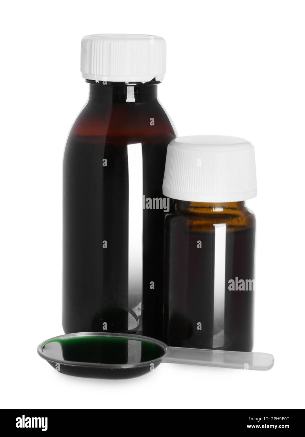 Bottles of cough syrup and dosing spoon on white background Stock Photo