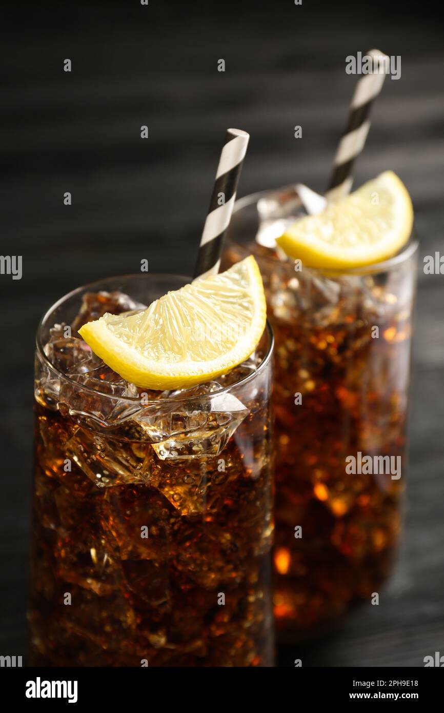 Glasses of refreshing soda water with ice cubes and lemon slices on ...
