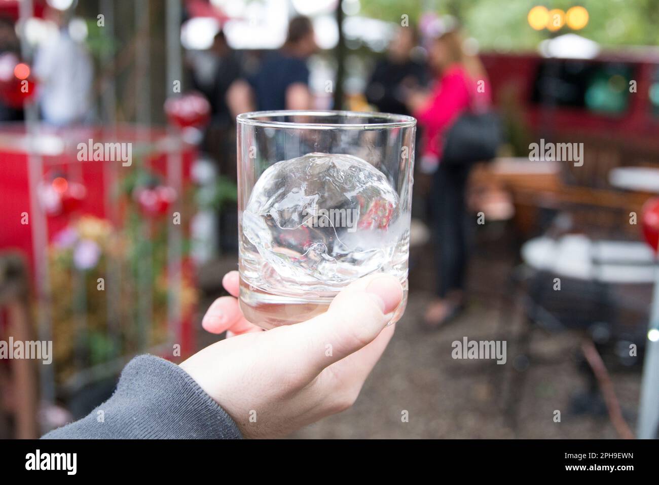 A professional bartender showing off a perfect ice bucket for drinks