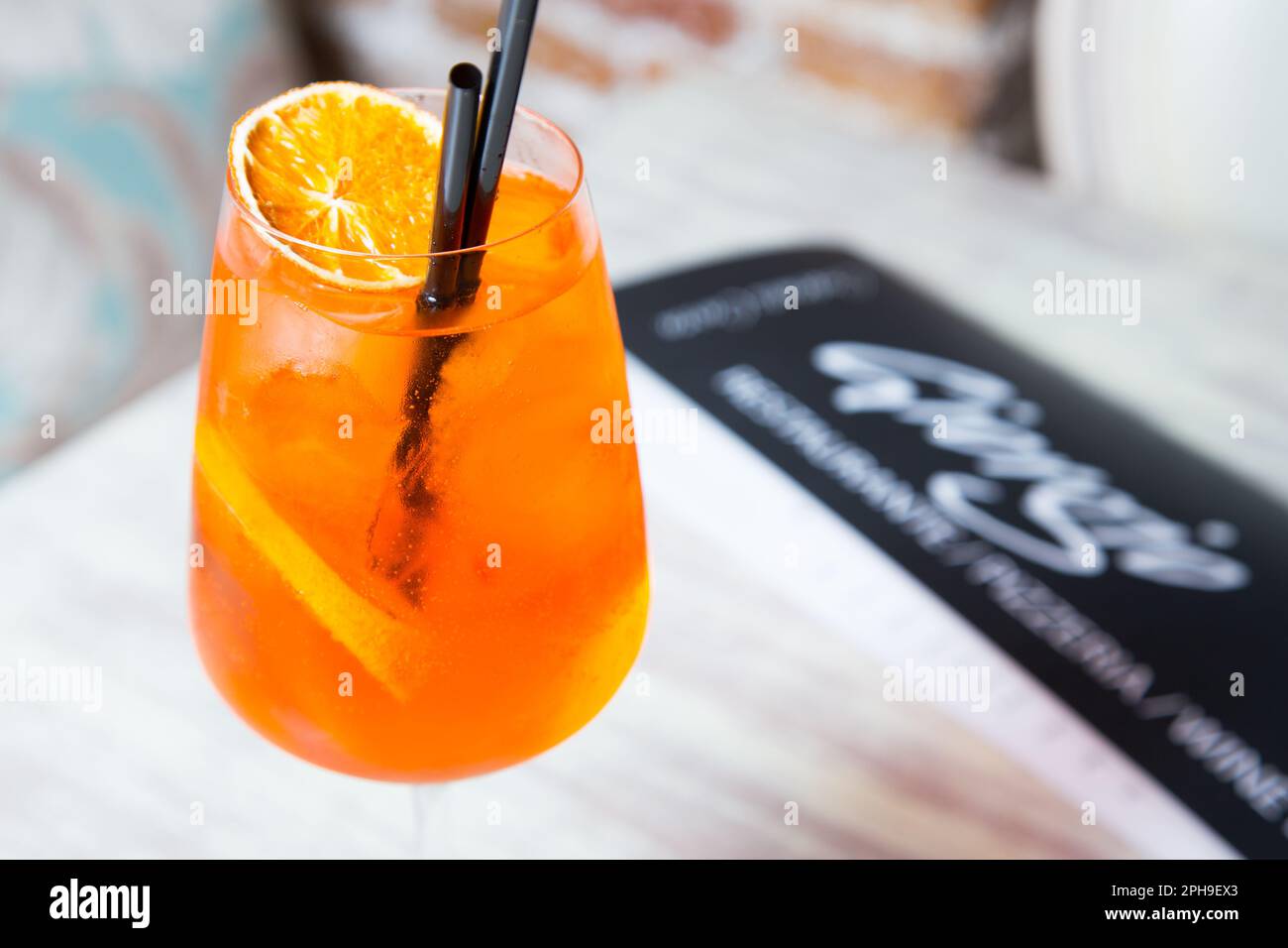 The Aperol Spritz is a well-known Italian long drink typical of the aperitif that mixes Aperol, prosecco and soda. Stock Photo