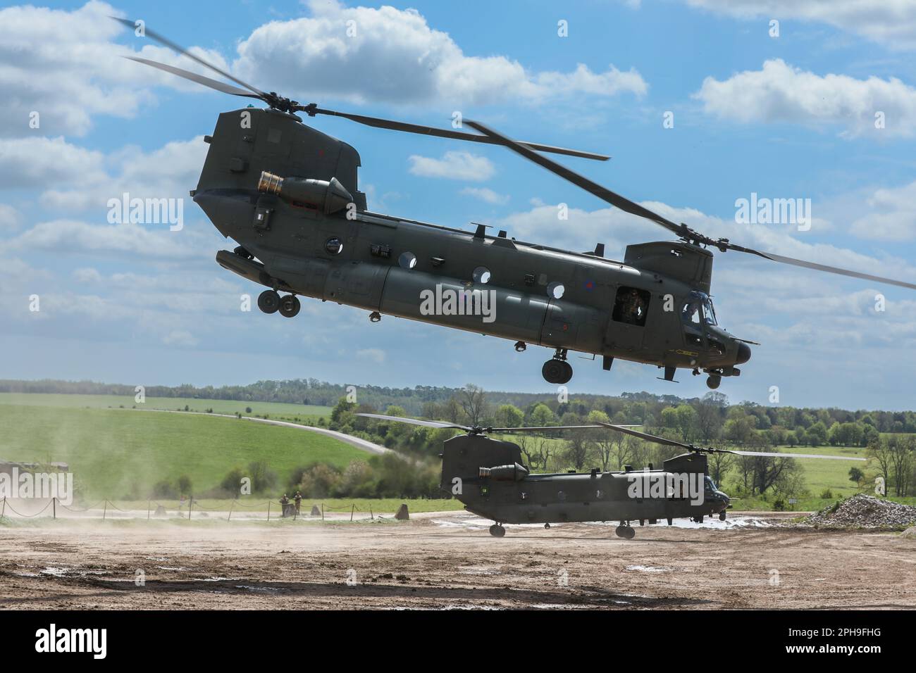 Two CH47 Chinook helicopters operated by the RAF getting airborne from Salisbury Plain, Wiltshire, England, UK Stock Photo