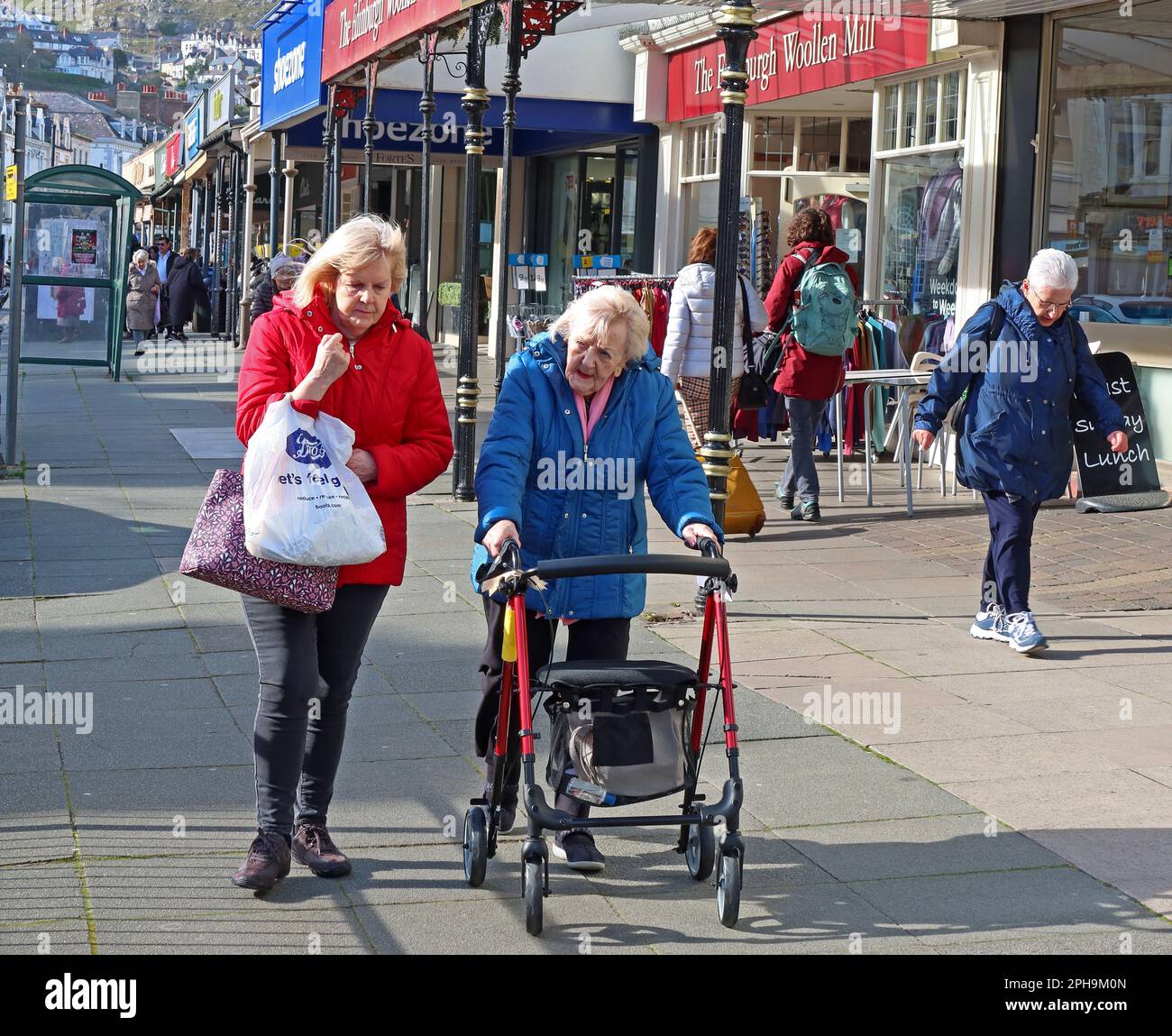 Older and elderly senior citizen shoppers, in Mostyn Street, Llandudno, Conwy County Borough, Wales, UK, LL30 2NN Stock Photo